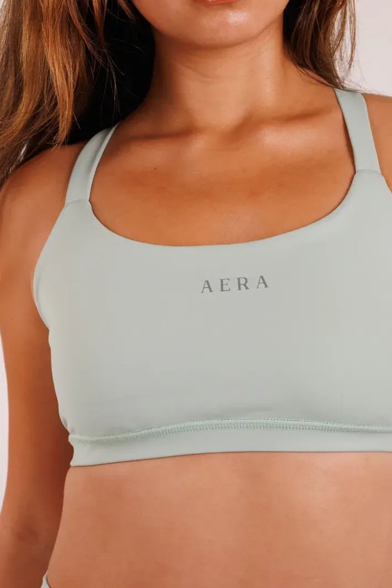 Crossover Bra na cor Verde sálvia, vista de frente. Moda fitness AERA, feita no Brasil.