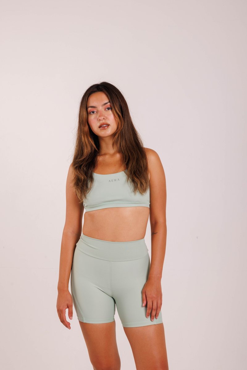 Crossover Bra na cor Verde sálvia, em movimento. Moda fitness AERA, feita no Brasil.