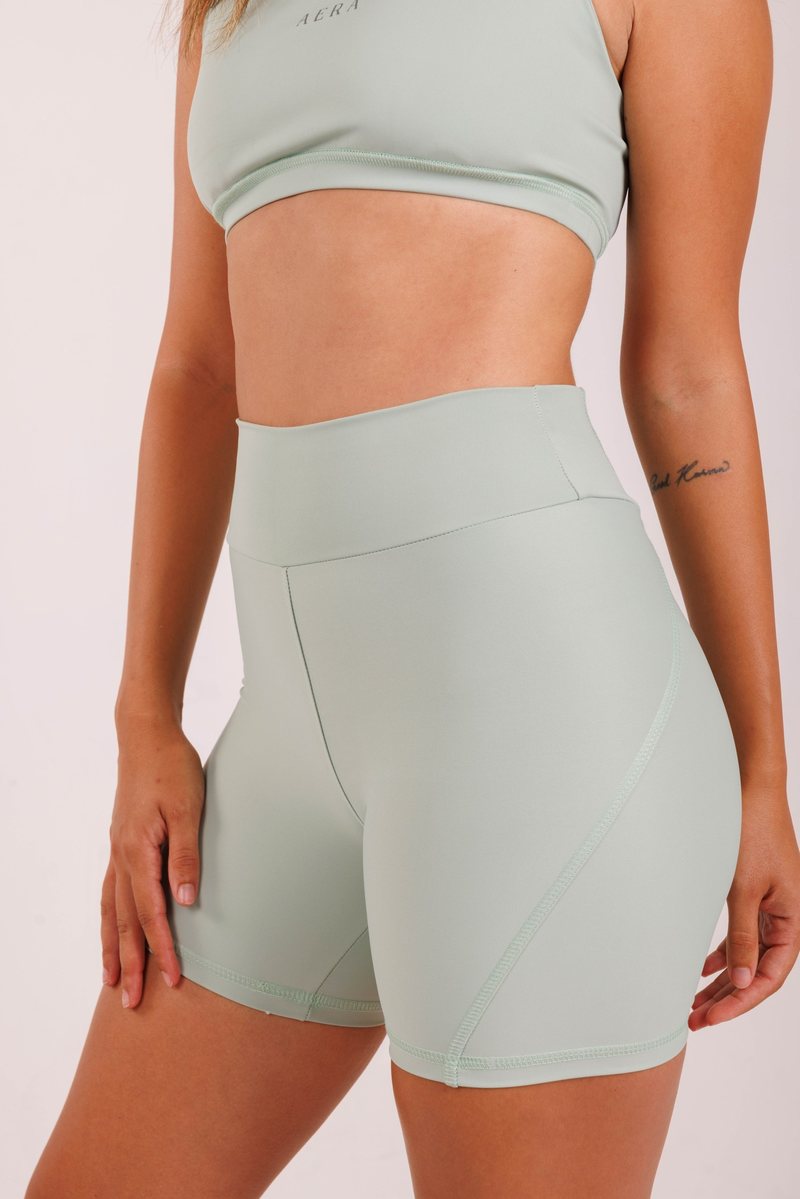 Meridian Biker Short na cor Verde sálvia, vista de frente. Moda fitness AERA, feita no Brasil.